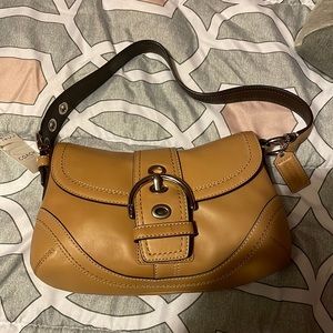 New with tags, Coach Soho leather, front snap flap .silver camel